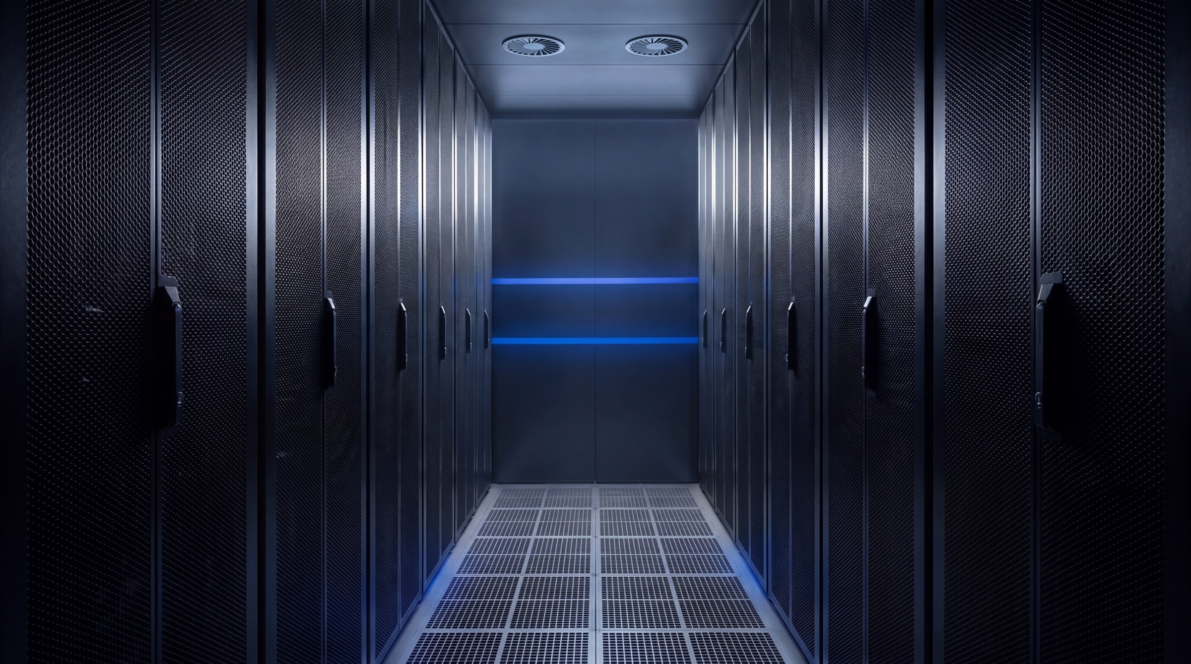 Corredor frio do datacenter Infotécnica com painéis perfurados e fitas guia azuis ao fundo